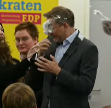 Sulmohet ish ministri gjerman/ Po fliste në podium, vajza i hedh shkumë rroje në fytyrë