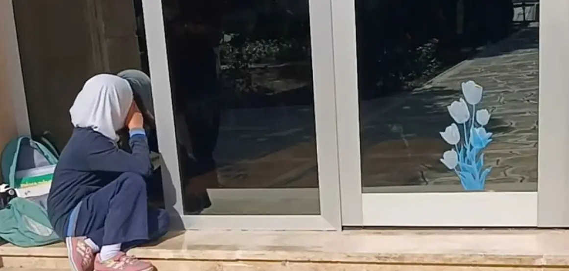Ndalimi i hixhabit në shkollat e Azerbajxhanit përmes një fotografie: vajza qan para derës së shkollës